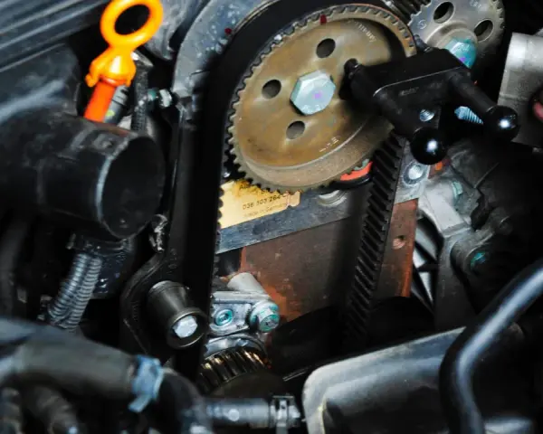 Ein Mechaniker arbeitet am Zahnriemenwechsel. Wann ist der richtige Zeitpunkt dafür?