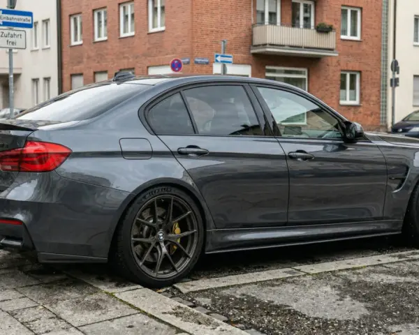 Grauer BMW M3 parkt auf Kopfsteinpflaster. Die Werkstatt bekommt das Ersatzteil nicht, der Wagen wartet.