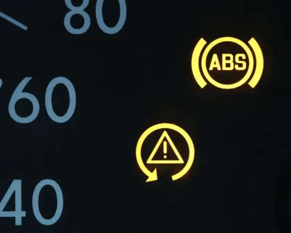Gelbe Kontrollleuchten im Auto: ABS-Symbol und allgemeines Warnsymbol. Vorsicht ist geboten.