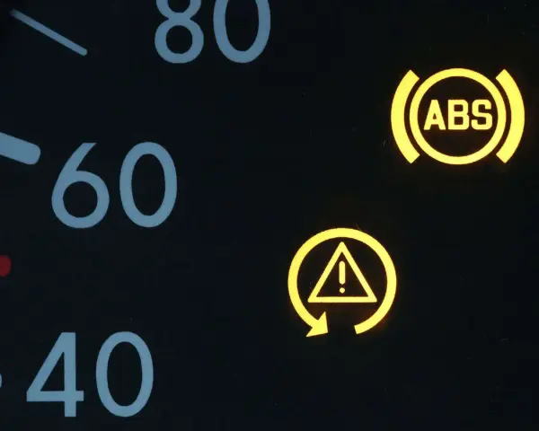 Armaturenbrett mit leuchtenden Warnleuchten: ABS und ESP-Symbol. Die ESP auto bedeutung ist, dass das elektronische Stabilitätsprogramm aktiv ist oder eine Störung vorliegt.