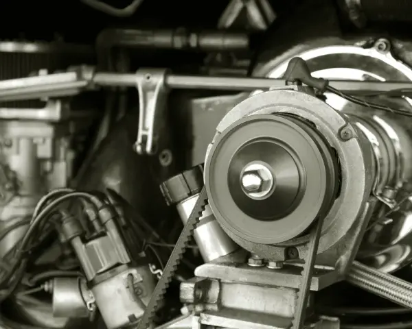 Nahaufnahme eines Motors, bei dem der Keilriemen gerissen ist. Man sieht die Riemenscheibe und Teile des Motors.