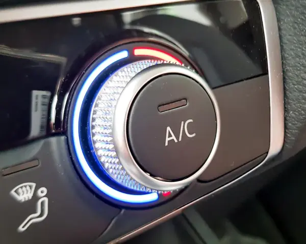 Detailaufnahme des Cockpits eines Autos. Ein Drehregler mit blauer und roter Beleuchtung steuert die Klimaanlage.