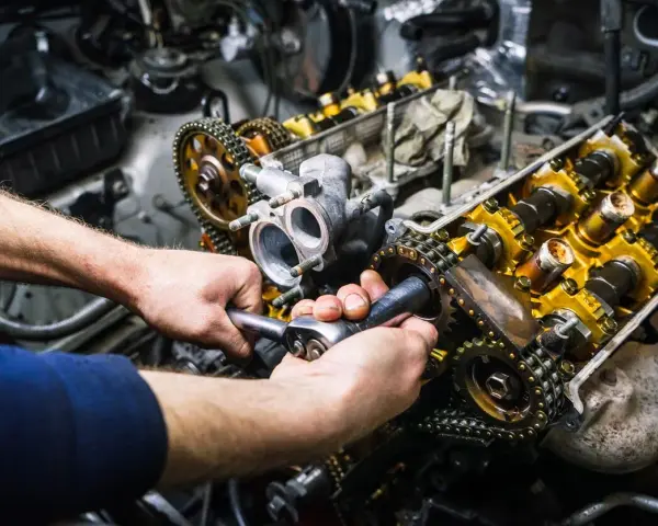 Mechaniker repariert einen Motor. Die Kosten für einen Motorschaden können hoch sein, aber eine Reparatur ist oft möglich.