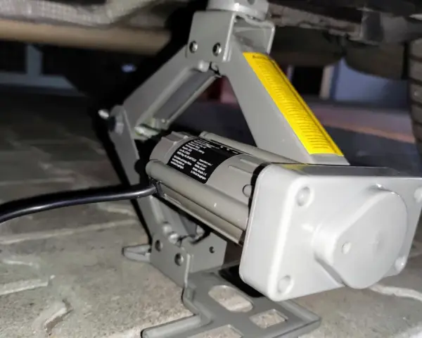 Elektrischer Wagenheber hebt das Auto an, um Reifen mit Reifendrucksensor selber zu wechseln.