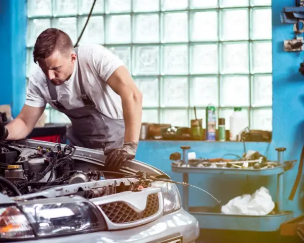 Mechaniker untersucht Motor. Er hofft, dass das Auto nach der Reparatur wieder funktioniert, aber es scheint, als ob das Auto nach Reparatur wieder defekt ist.