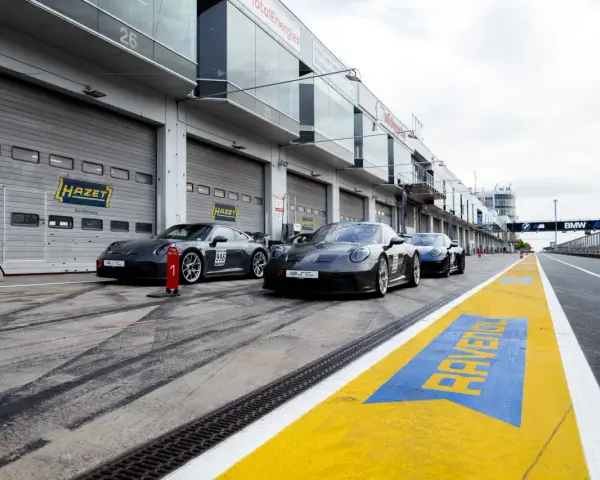 Porsche-Rennwagen in Boxengasse. Hier kann man pitstop teile selber mitbringen. Gelbe Markierungen auf dem Asphalt.