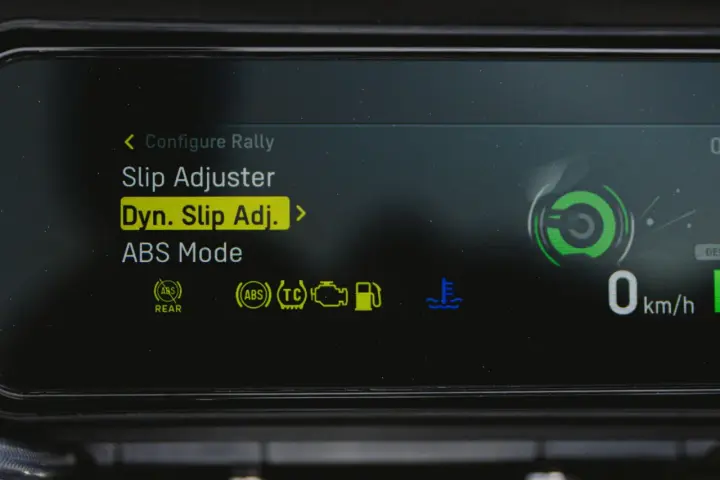 Fahrzeugdisplay zeigt Einstellungen für Traktionskontrolle (TC) und ABS. "Dyn. Slip Adj." ist hervorgehoben.