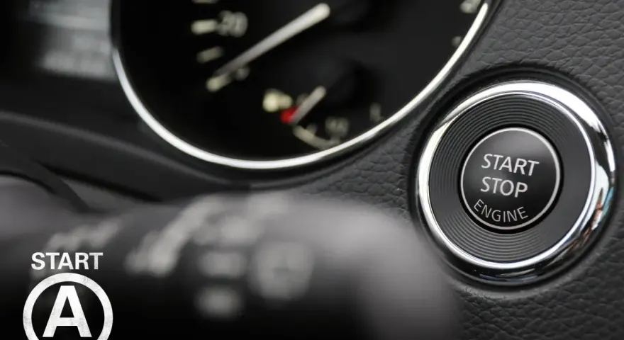 Startknopf im Auto mit Kreis und Pfeilen, bereit für die Fahrt.