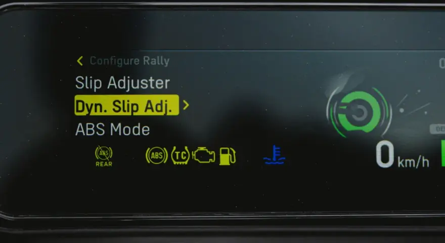 Fahrzeugdisplay zeigt Einstellungen für Traktionskontrolle (TC) und ABS. "Dyn. Slip Adj." ist hervorgehoben.