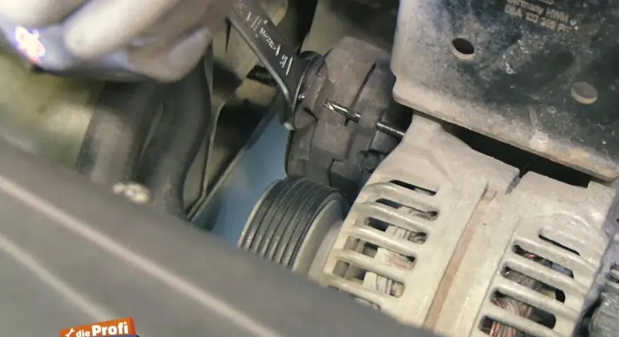 Werkzeug wird benutzt, um den Keilriemen zu spannen. Ein Keilriemen ist ein wichtiger Bestandteil des Motors.