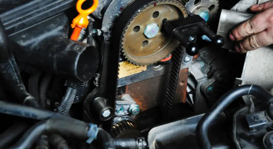 Ein Mechaniker arbeitet am Zahnriemenwechsel. Wann ist der richtige Zeitpunkt dafür?