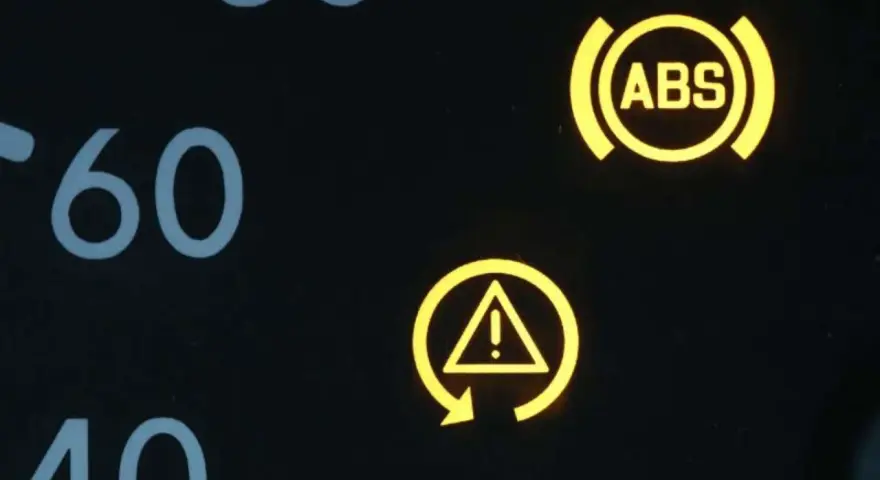 Gelbe Kontrollleuchten im Auto: ABS-Symbol und allgemeines Warnsymbol. Vorsicht ist geboten.