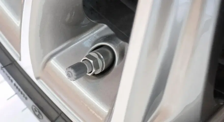 Nahaufnahme eines Autoreifenventils, das undicht zu sein scheint. Der Gummi ist leicht beschädigt.