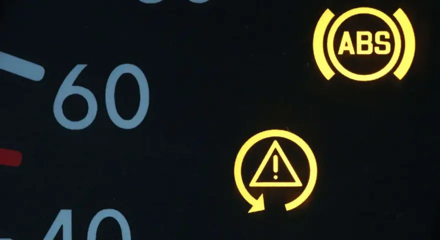 Armaturenbrett mit leuchtenden Warnleuchten: ABS und ESP-Symbol. Die ESP auto bedeutung ist, dass das elektronische Stabilitätsprogramm aktiv ist oder eine Störung vorliegt.