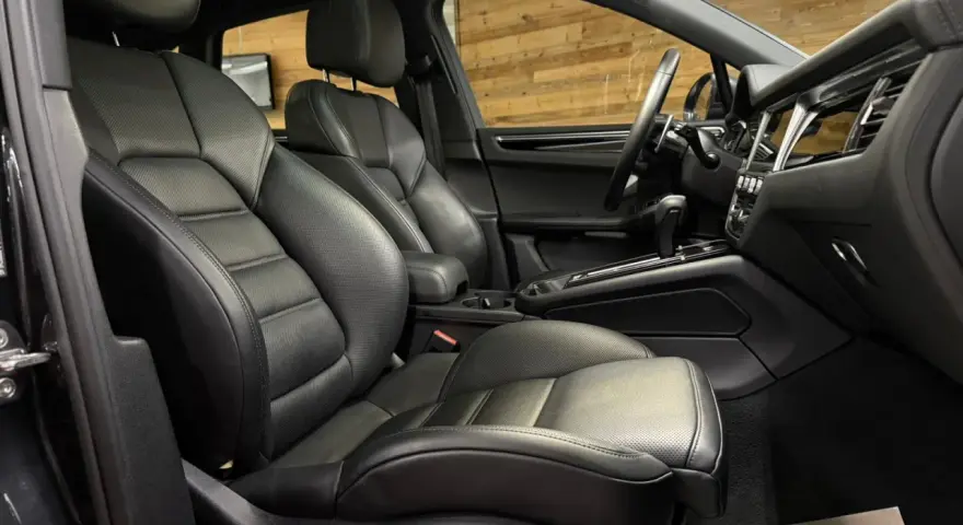 Der luxuriöse porsche macan s innenraum mit perforierten Ledersitzen und einem modernen Armaturenbrett.