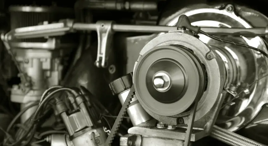 Nahaufnahme eines Motors, bei dem der Keilriemen gerissen ist. Man sieht die Riemenscheibe und Teile des Motors.