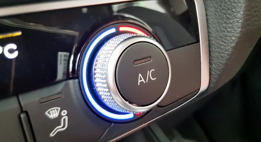 Detailaufnahme des Cockpits eines Autos. Ein Drehregler mit blauer und roter Beleuchtung steuert die Klimaanlage.