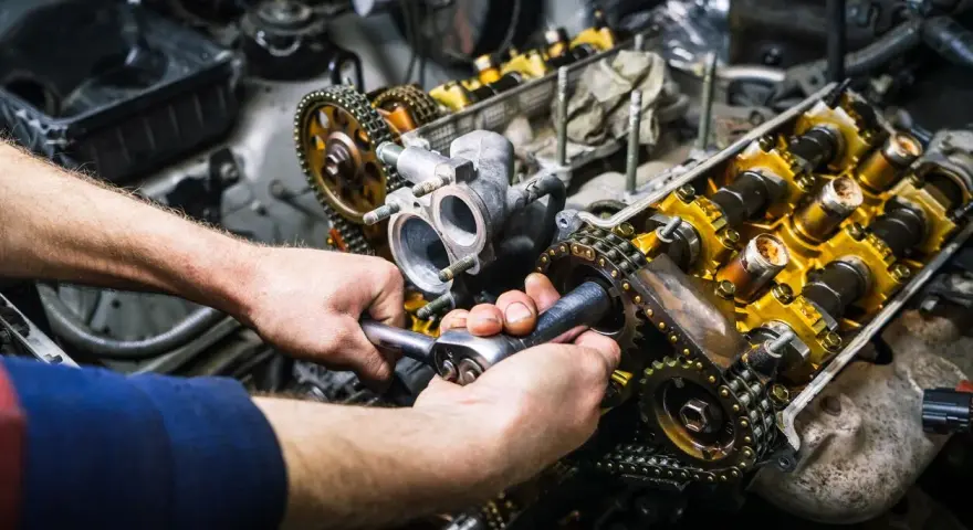 Mechaniker repariert einen Motor. Die Kosten für einen Motorschaden können hoch sein, aber eine Reparatur ist oft möglich.