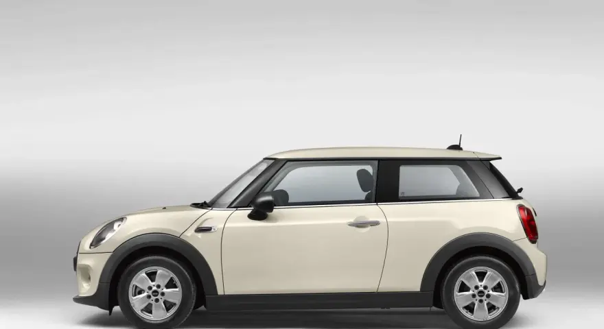 Beiger Mini Cooper im Profil. Ein Blick auf den Mini Cooper wartungsplan hilft, diesen Klassiker in Topform zu halten.