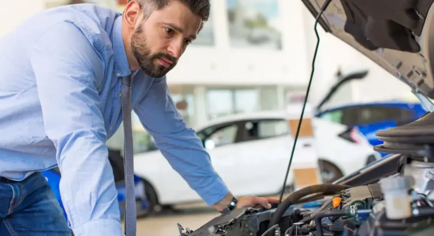 Mann prüft Motor, weil das Auto nicht mehr richtig beschleunigt.