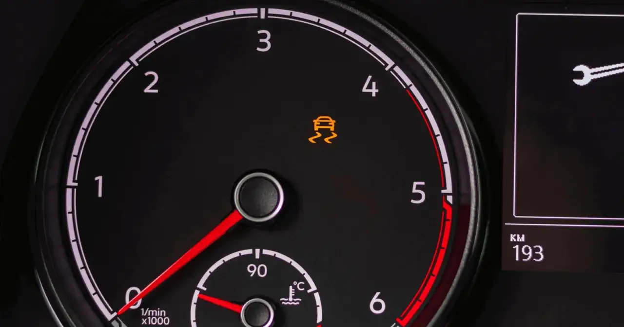 Warnleuchte f&uuml;r die Traktionskontrolle im Auto leuchtet gelb. Das Symbol zeigt ein schleuderndes Auto.