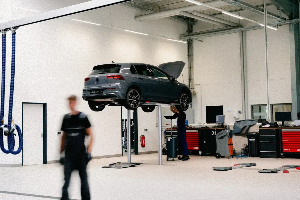 Ein VW Polo wird in einer Werkstatt auf einer Hebebühne inspiziert. Die Kosten für die Inspektion sind hier nicht ersichtlich.