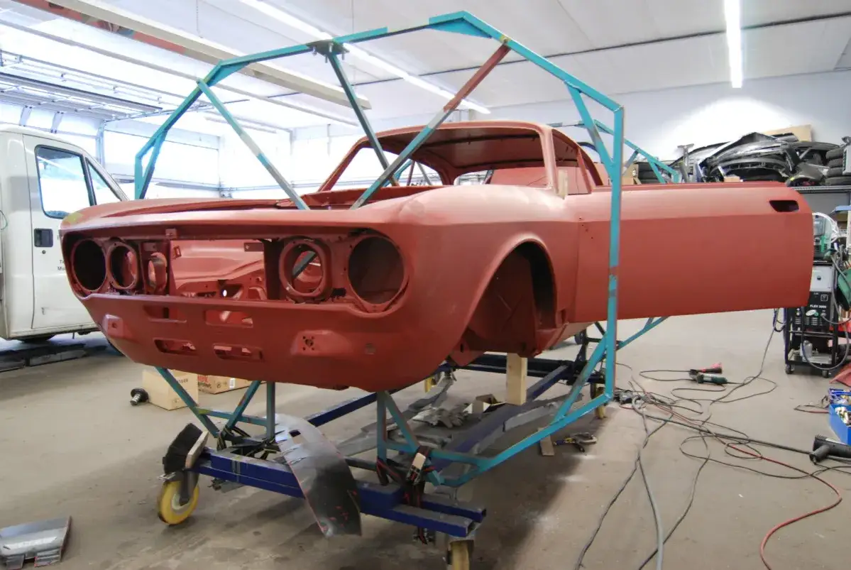 Roter Oldtimer im Lackierprozess, bereit für neue Farbe. Die Oldtimer Lackieren Kosten hängen vom Aufwand ab.