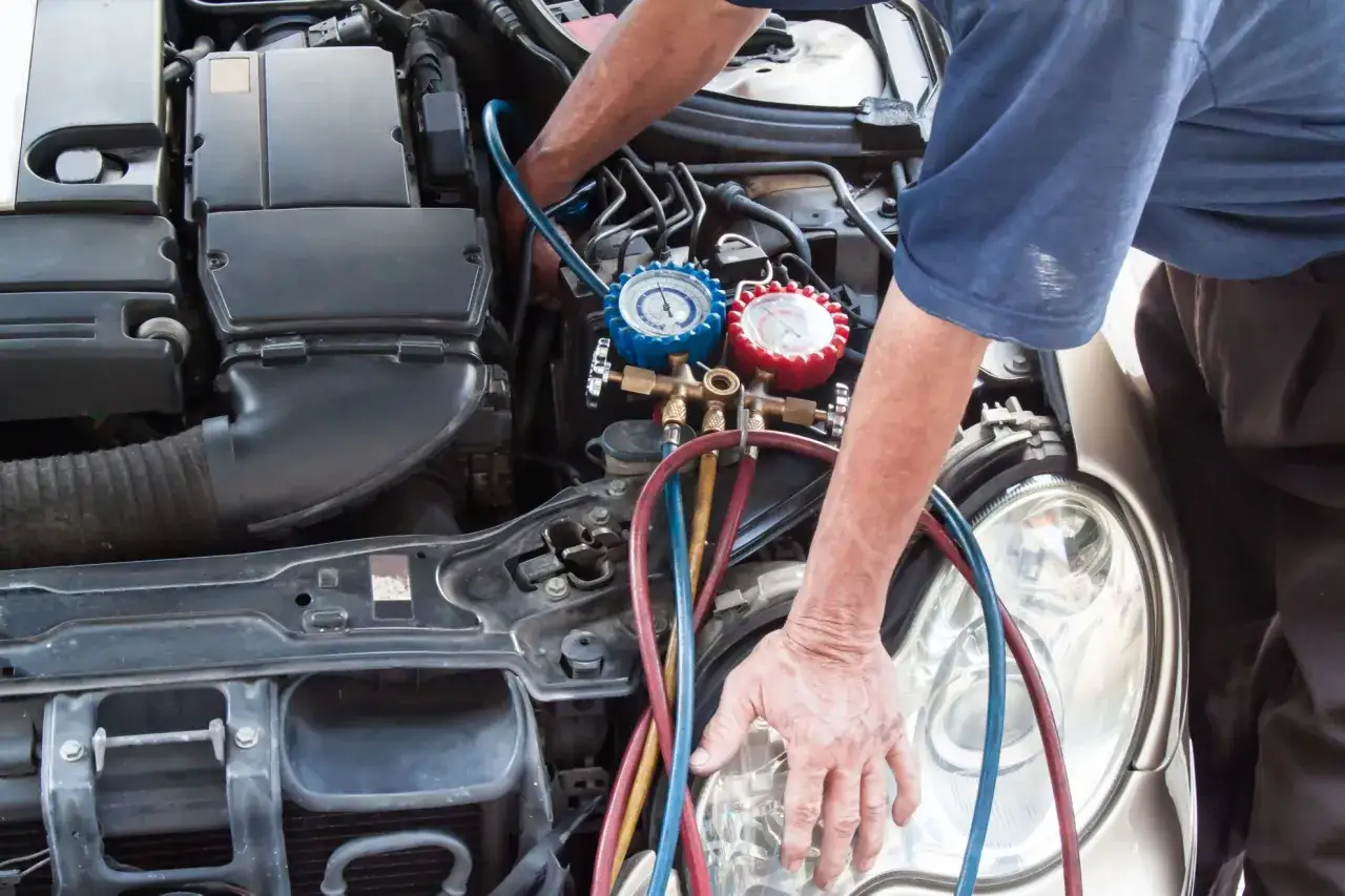 Mechaniker pr&uuml;ft Klimaanlage mit Manometern. Informieren Sie sich &uuml;ber die Klimaanlage reparieren kosten.