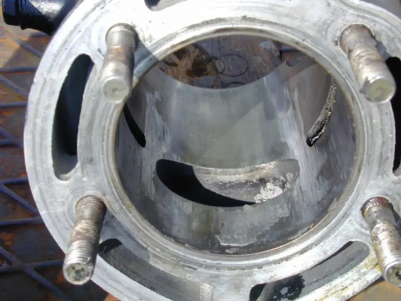 Besch&auml;digter Zylinder mit deutlichen Spuren, die auf einen Kolbenfresser erkennen lassen. Metallteile sind abgebrochen und die Oberfl&auml;che ist stark abgerieben.