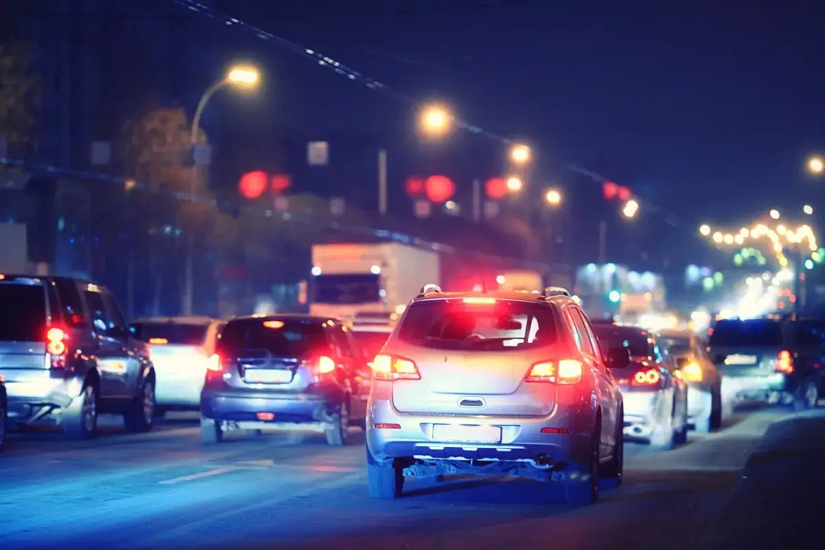 Autos im Stau bei Nacht. Ein Wagen hat ein defektes Bremslicht, das nicht funktioniert.