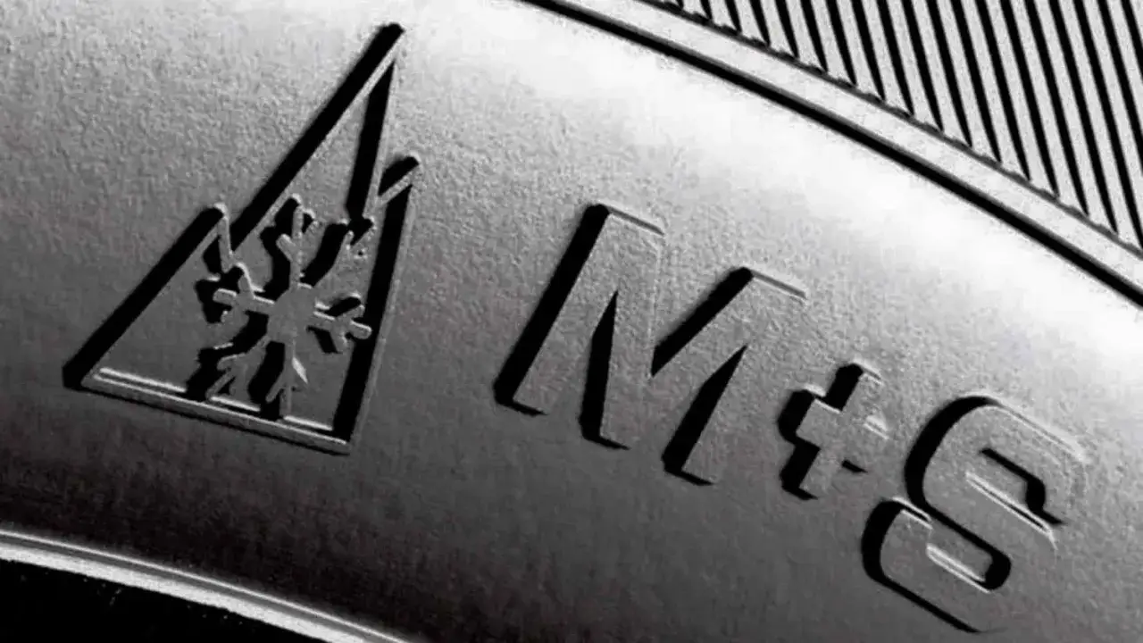 Nahaufnahme eines Reifens mit Schneeflockensymbol und der Kennzeichnung M+S für Matsch und Schnee.
