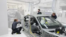 Mitarbeiter arbeiten an einem Auto-Chassis. Sie sind Teil eines Teams, das sich mit der Frage beschäftigt, was OEMs sind und wie sie in der Automobilproduktion eingesetzt werden.