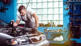 Mechaniker untersucht Motor. Er hofft, dass das Auto nach der Reparatur wieder funktioniert, aber es scheint, als ob das Auto nach Reparatur wieder defekt ist.