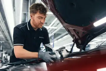 Mechaniker mit BMW Service Polohemd arbeitet an einem Turbolader für ein BMW CBS Fahrzeug.