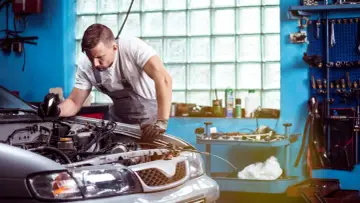 Mechaniker untersucht Motor. Er hofft, dass das Auto nach der Reparatur wieder funktioniert, aber es scheint, als ob das Auto nach Reparatur wieder defekt ist.