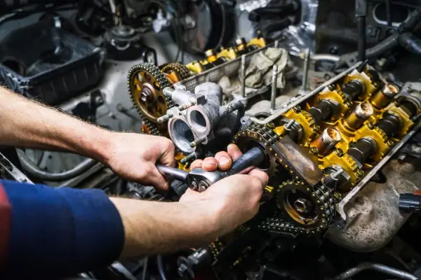 Mechaniker repariert einen Motor. Die Kosten für einen Motorschaden können hoch sein, aber eine Reparatur ist oft möglich.