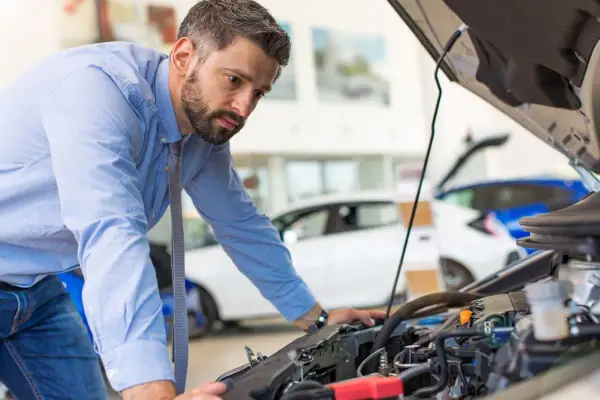 Mann prüft Motor, weil das Auto nicht mehr richtig beschleunigt.
