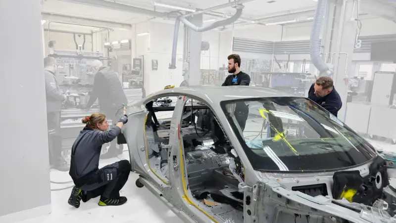 Mitarbeiter arbeiten an einem Auto-Chassis. Sie sind Teil eines Teams, das sich mit der Frage beschäftigt, was OEMs sind und wie sie in der Automobilproduktion eingesetzt werden.