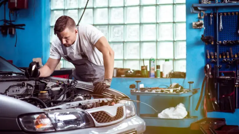 Mechaniker untersucht Motor. Er hofft, dass das Auto nach der Reparatur wieder funktioniert, aber es scheint, als ob das Auto nach Reparatur wieder defekt ist.